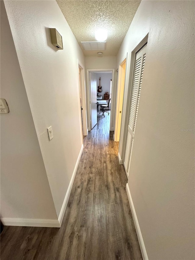 hall with hardwood / wood-style flooring and a textured ceiling