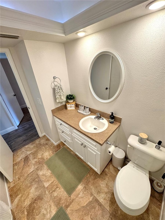 bathroom with vanity, toilet, and crown molding