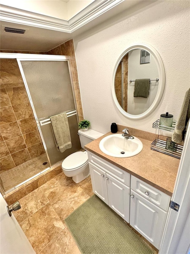 bathroom with vanity, toilet, and a shower with door