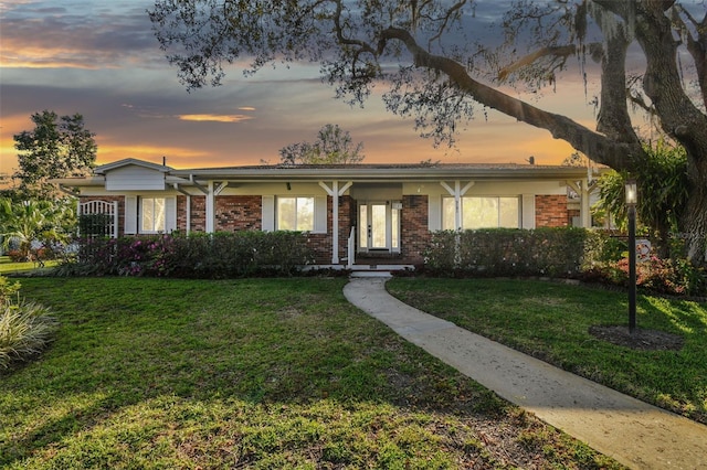 ranch-style house featuring brick siding and a front yard