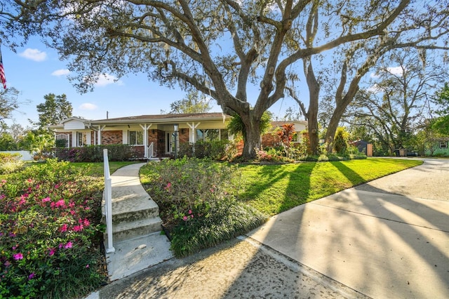 ranch-style house with brick siding and a front lawn