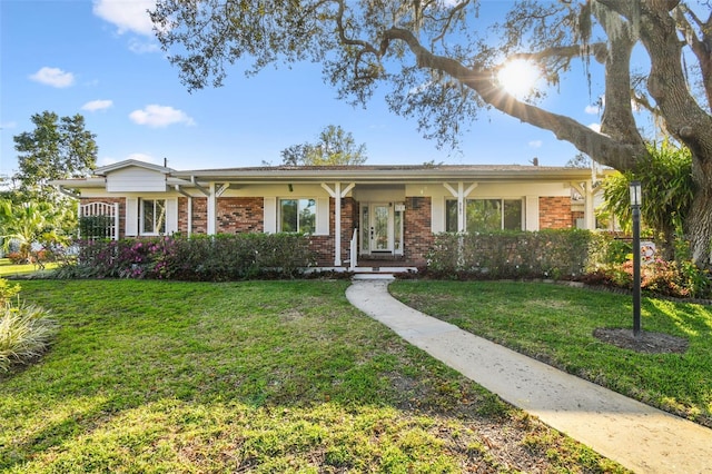 ranch-style home featuring a front yard and brick siding