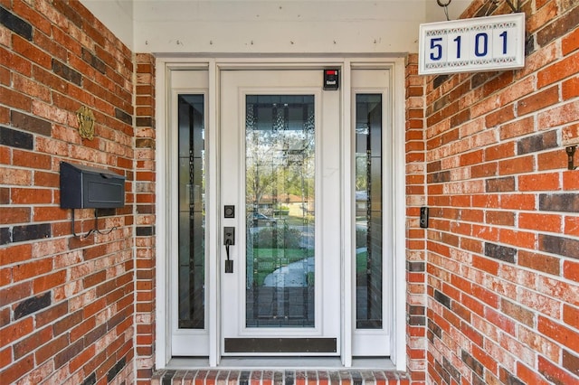 property entrance featuring brick siding