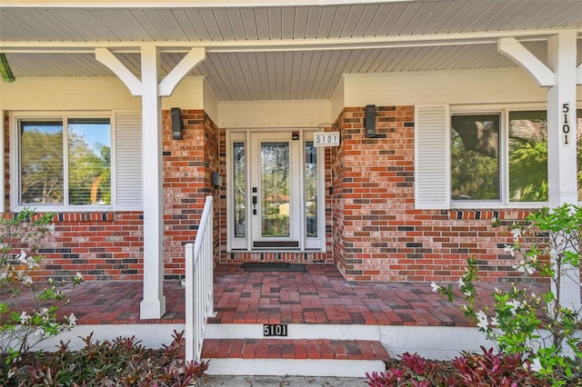 entrance to property featuring brick siding