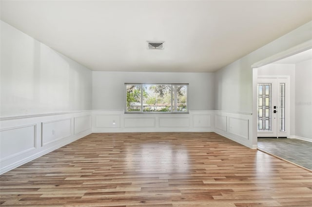 empty room featuring visible vents and wood finished floors