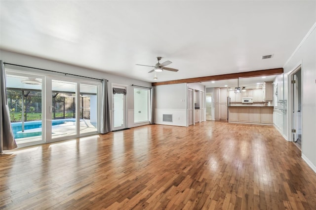 unfurnished living room with baseboards, visible vents, ceiling fan, and light wood finished floors