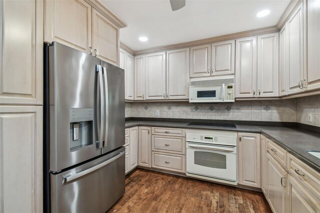 kitchen featuring dark wood-style floors, white appliances, dark countertops, and decorative backsplash