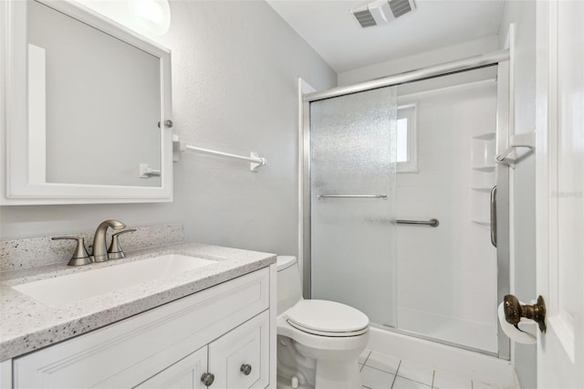 full bathroom featuring tile patterned flooring, toilet, vanity, visible vents, and a stall shower