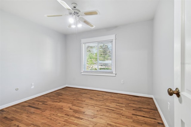 empty room with ceiling fan, baseboards, and wood finished floors