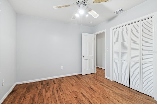 unfurnished bedroom featuring baseboards, visible vents, and wood finished floors