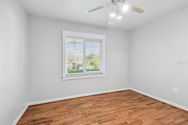 unfurnished room with a ceiling fan, baseboards, and wood finished floors