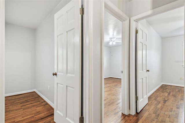 hallway featuring wood-type flooring and baseboards