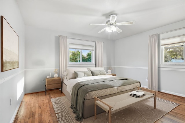 bedroom featuring wood-type flooring, baseboards, and ceiling fan