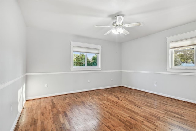 empty room featuring wood-type flooring, ceiling fan, and baseboards