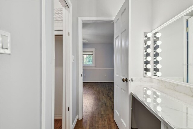 hallway with baseboards and dark wood-style flooring