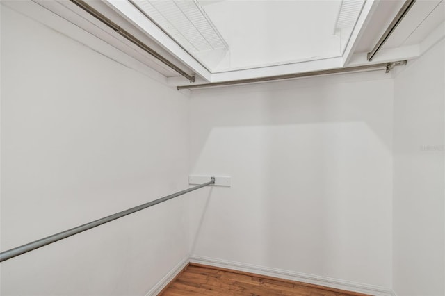 walk in closet with light wood-style floors