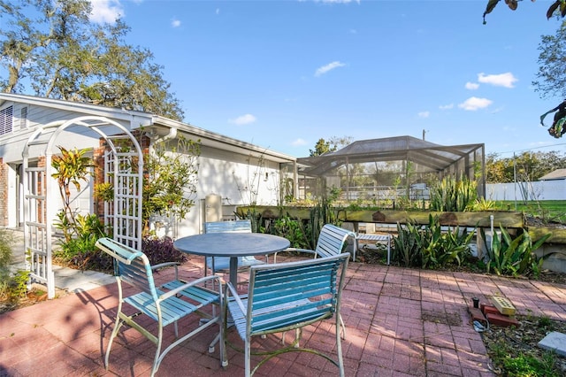 view of patio with a lanai and outdoor dining area