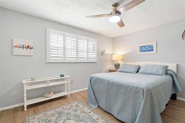 bedroom featuring ceiling fan, a textured ceiling, and light hardwood / wood-style floors