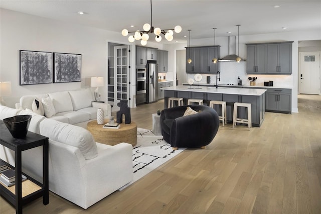 living room featuring light wood-type flooring and a chandelier