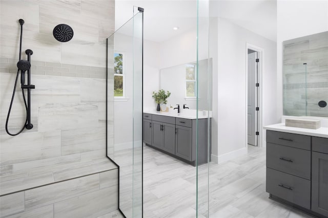 bathroom featuring tiled shower and vanity