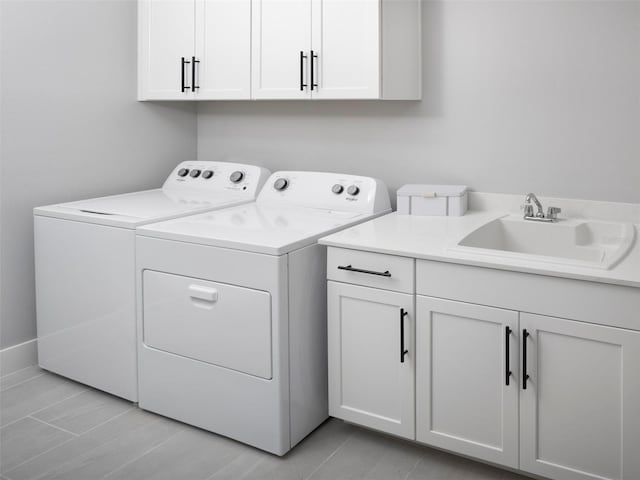 laundry room featuring washer and dryer, cabinets, light tile patterned floors, and sink