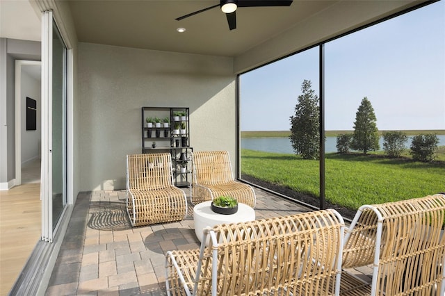 sunroom / solarium featuring a water view and ceiling fan