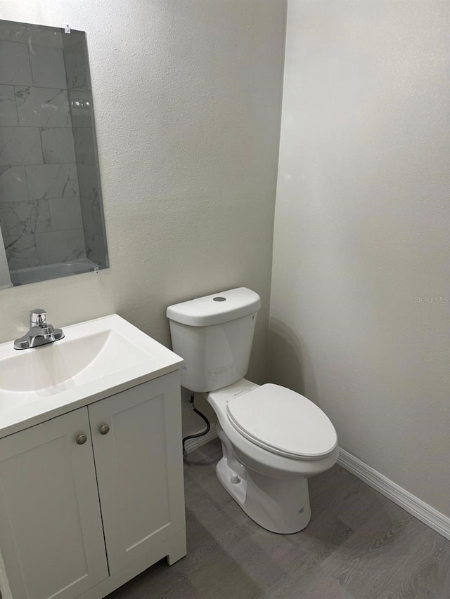 bathroom with vanity, toilet, and hardwood / wood-style floors