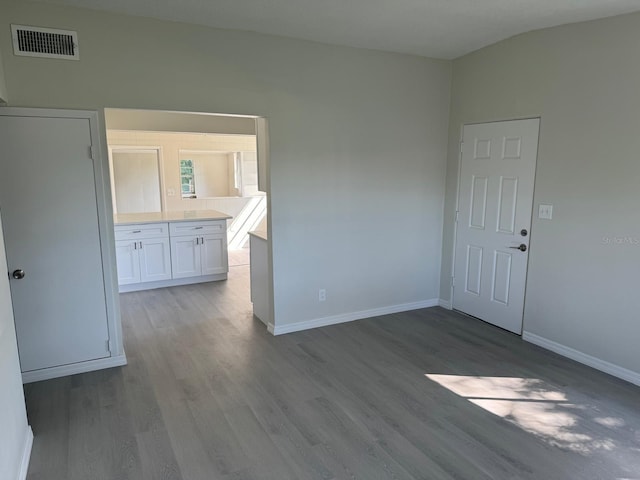 spare room featuring light hardwood / wood-style floors and lofted ceiling