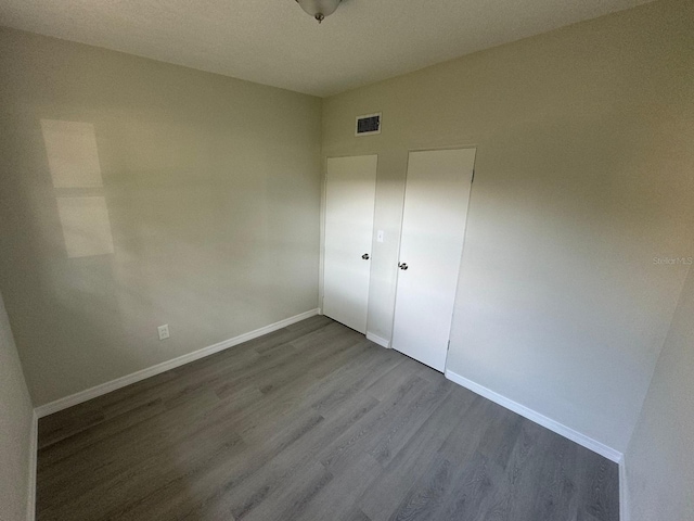 unfurnished bedroom with a closet and hardwood / wood-style flooring