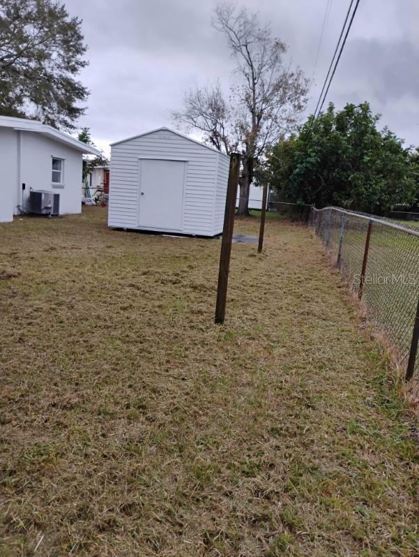 view of yard featuring central AC unit and a shed