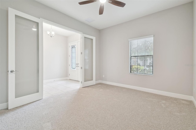 carpeted empty room with ceiling fan and french doors