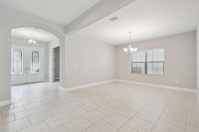 empty room featuring light tile patterned floors, beamed ceiling, a chandelier, and a healthy amount of sunlight