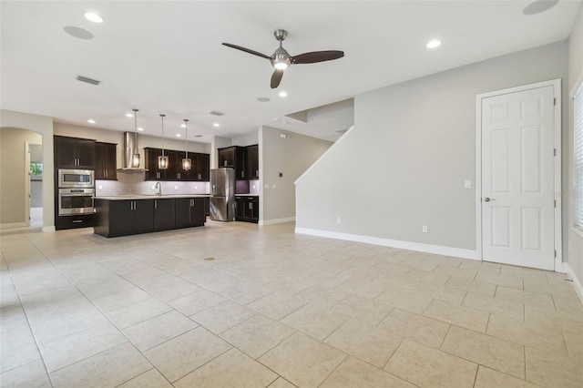 unfurnished living room with sink, light tile patterned flooring, and ceiling fan