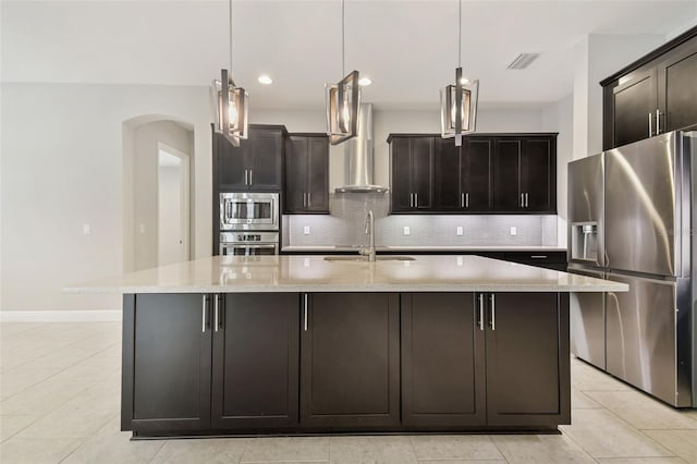 kitchen with hanging light fixtures, a kitchen island with sink, and appliances with stainless steel finishes