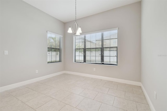 unfurnished room with an inviting chandelier and light tile patterned flooring