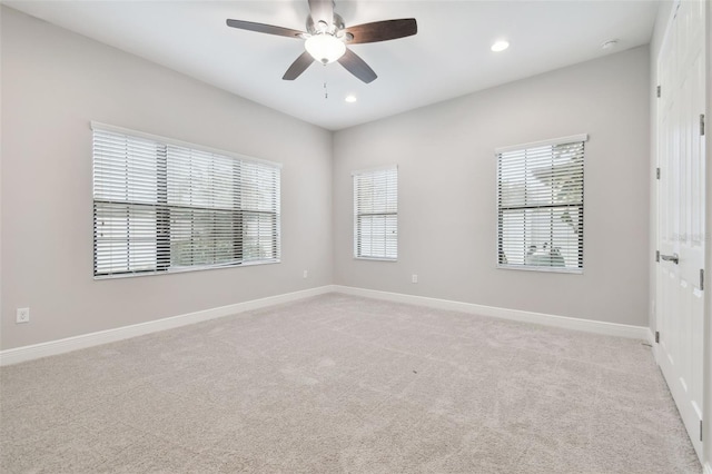 unfurnished room with light colored carpet and ceiling fan