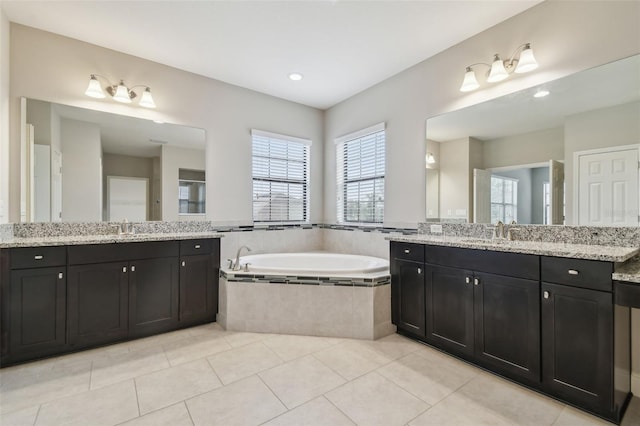 bathroom with vanity, tile patterned floors, and tiled bath