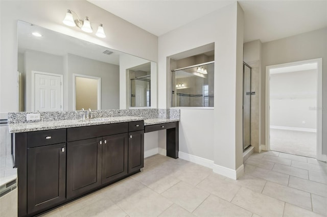 bathroom featuring tile patterned floors, a shower with door, and vanity