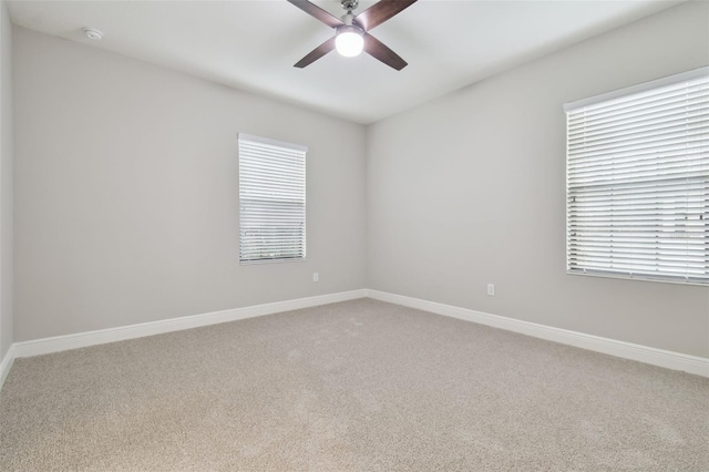 carpeted spare room with ceiling fan