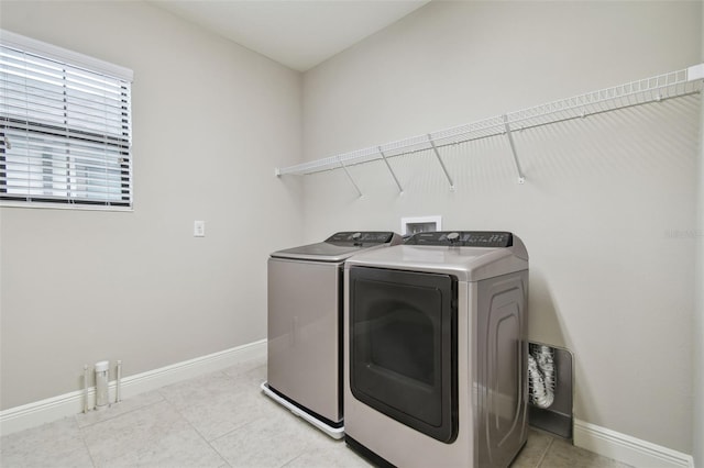 clothes washing area featuring washer and dryer and light tile patterned floors