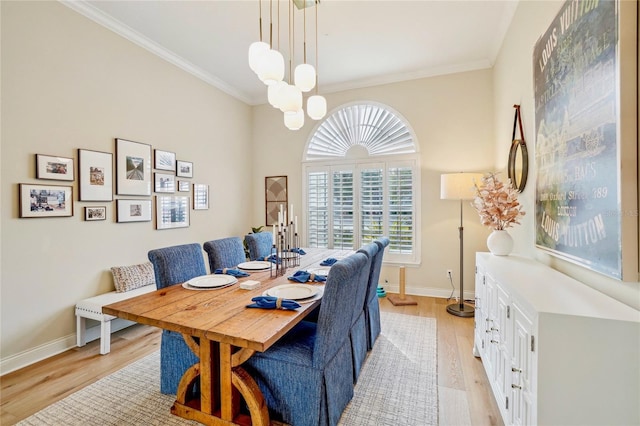 dining space with ornamental molding, a notable chandelier, and light hardwood / wood-style floors