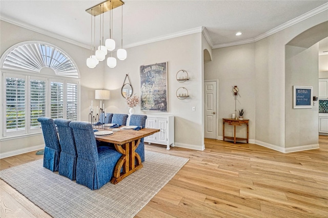 dining space with crown molding, light wood-type flooring, and a chandelier