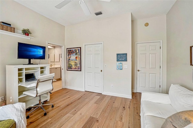 home office with ceiling fan and light hardwood / wood-style flooring