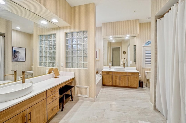 bathroom featuring vanity, a bathing tub, and toilet