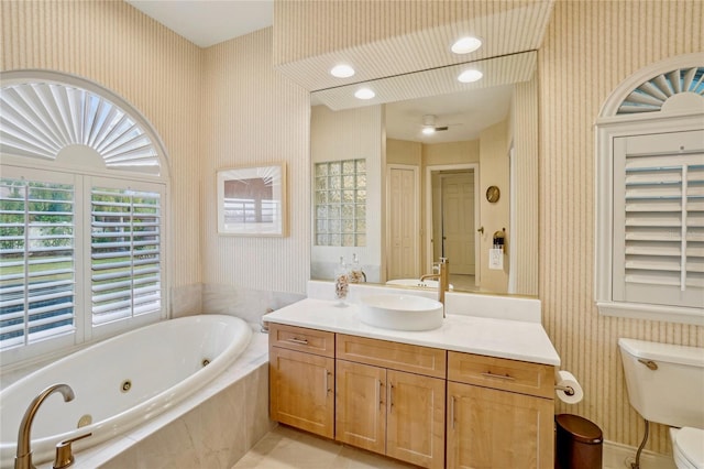 bathroom featuring vanity, tiled bath, tile patterned floors, and toilet