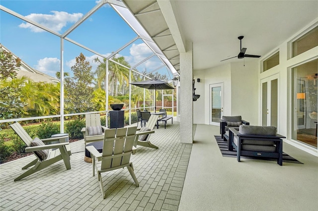 view of patio with a lanai, outdoor lounge area, and ceiling fan