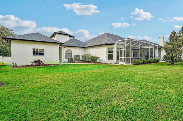 rear view of property with a yard, a lanai, and central AC unit