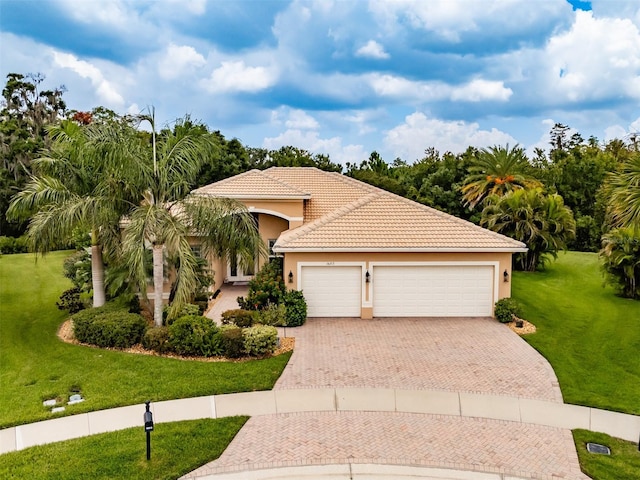 mediterranean / spanish home featuring a garage and a front lawn