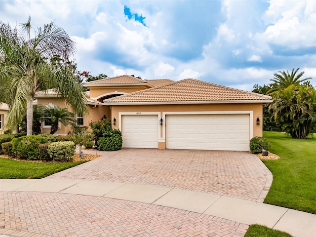 mediterranean / spanish house featuring a garage and a front lawn