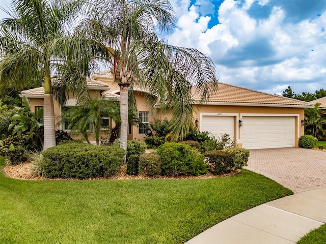 mediterranean / spanish-style home featuring a garage and a front lawn